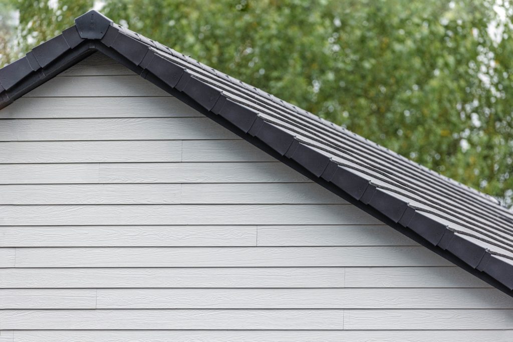 Domestic building clad in Marley's white fibre cement cladding with tree background