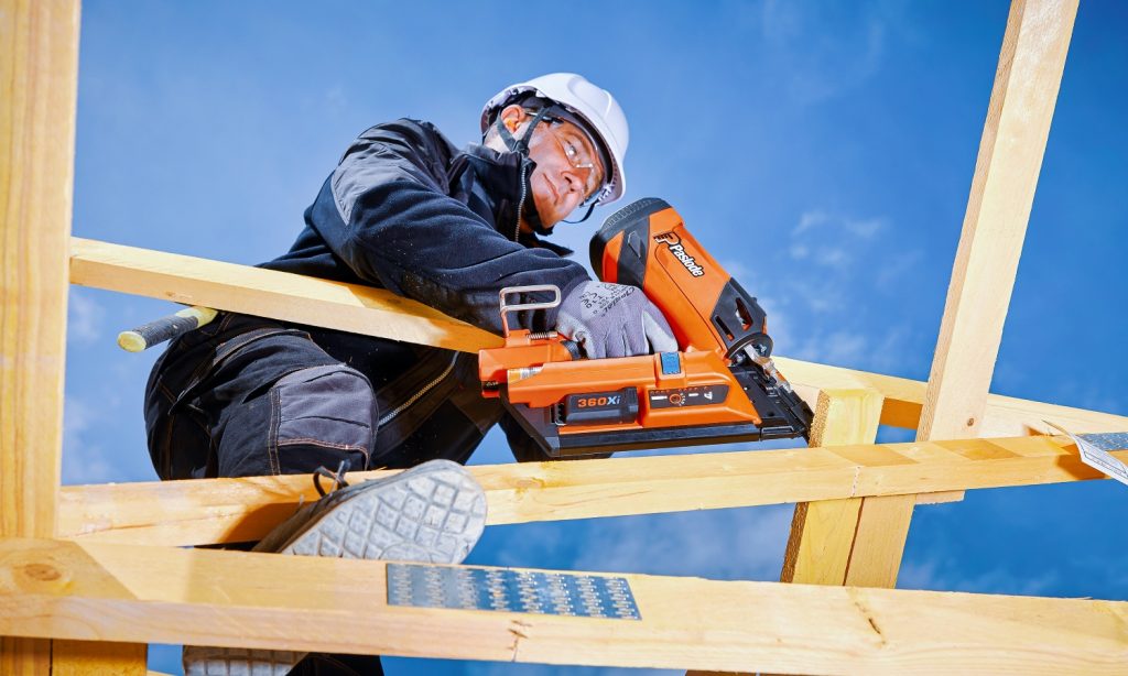 Worker uses Paslode 360 Xi nailer on timber frame